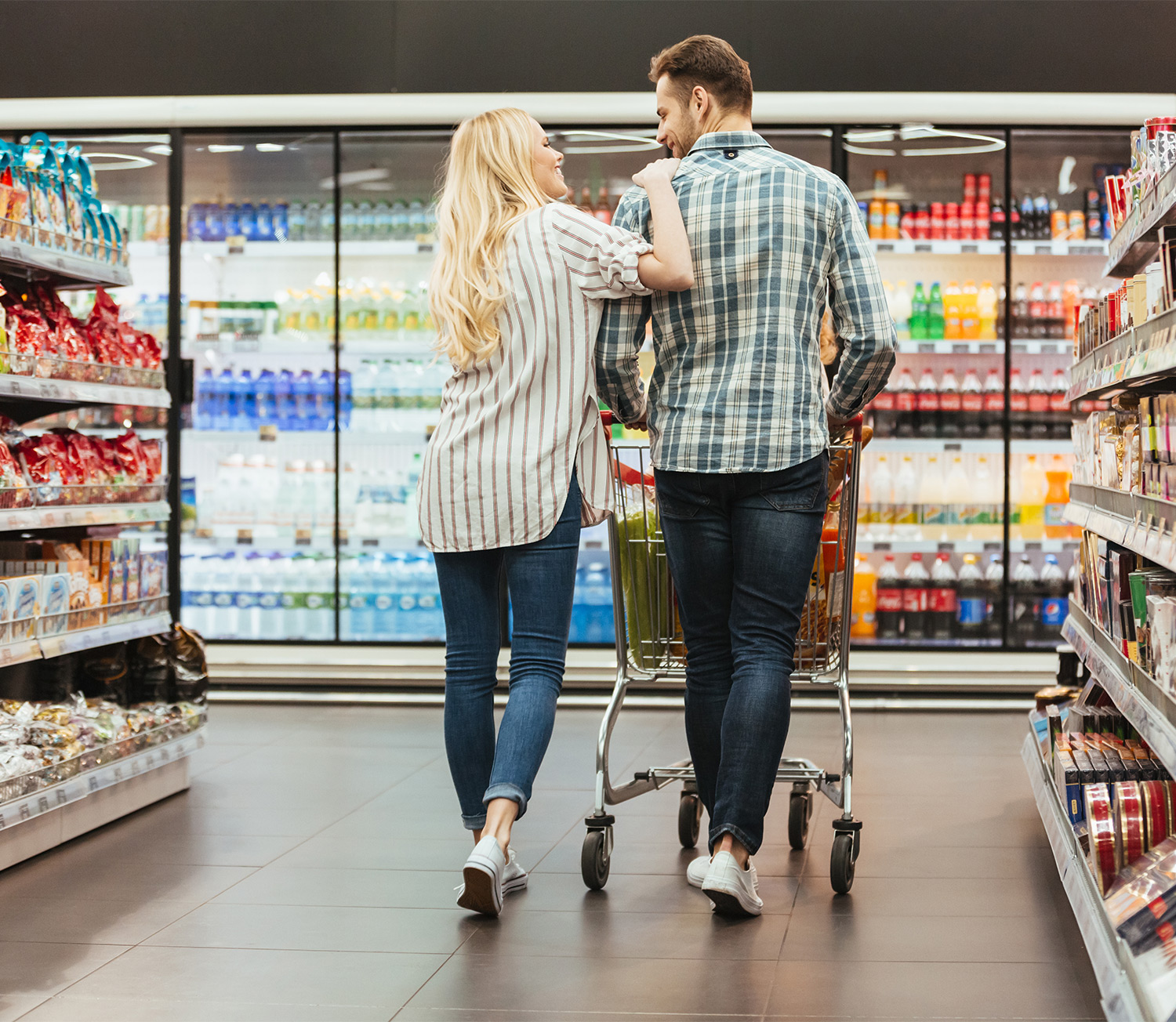 back-view-of-smiling-couple-walking-with-trolley