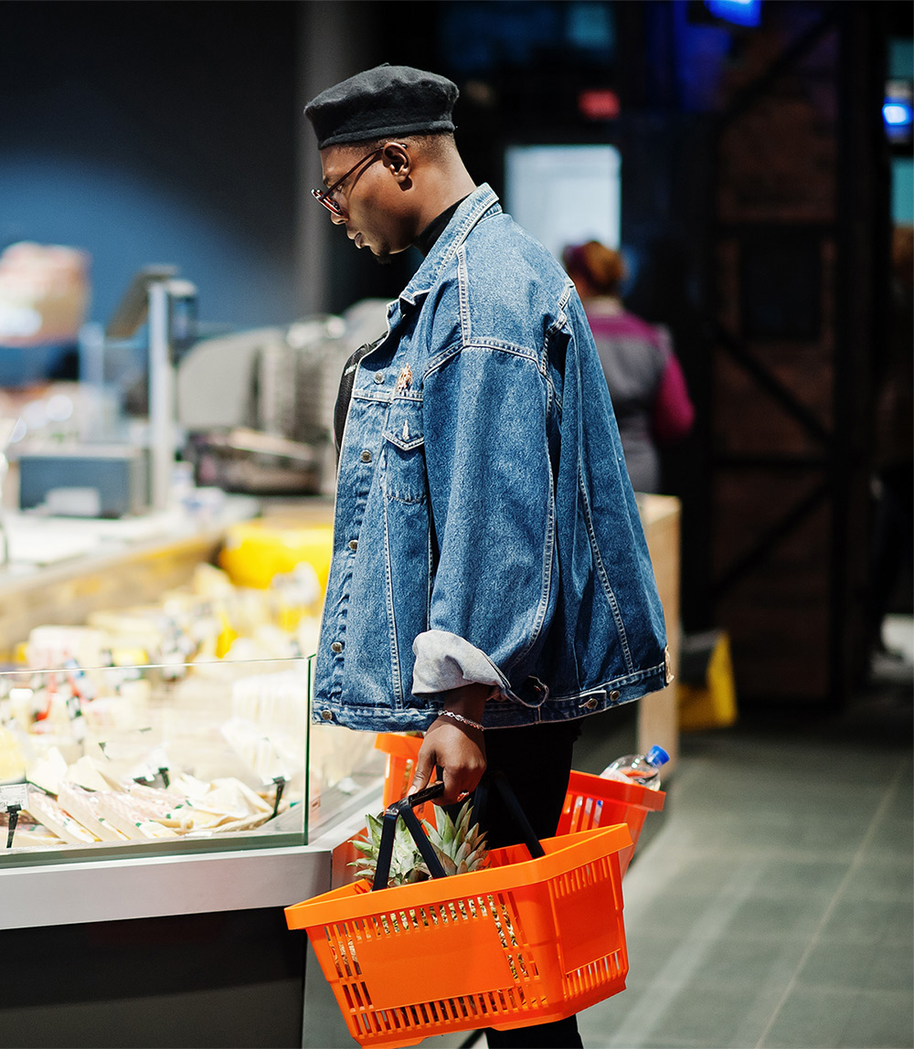 stylish-casual-african-american-man-jeans-jacket-black-beret-holding-basket-standing-near-cheese-fridge-shopping-supermarket