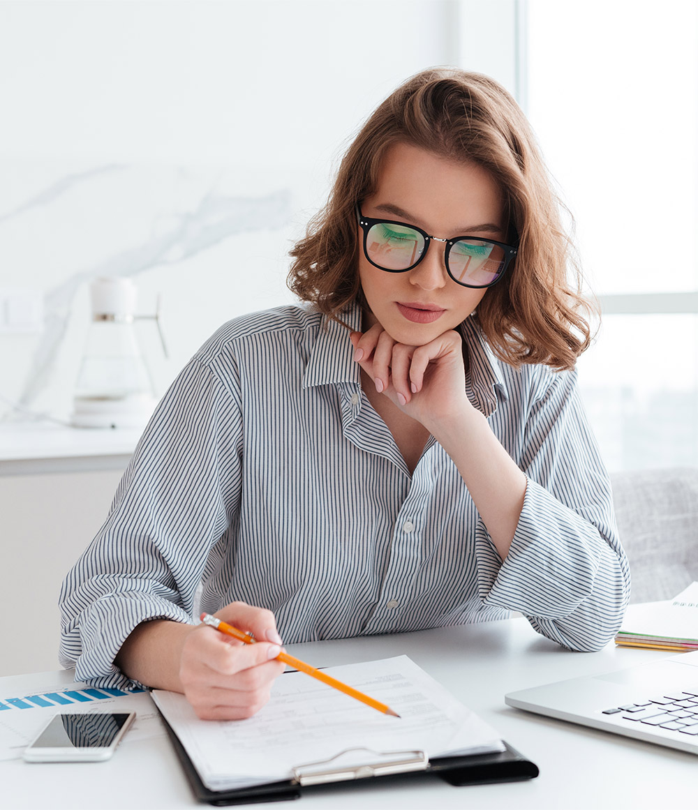 young-concentrated-businesswoman-glasses-striped-shirt-working-with-papers-home